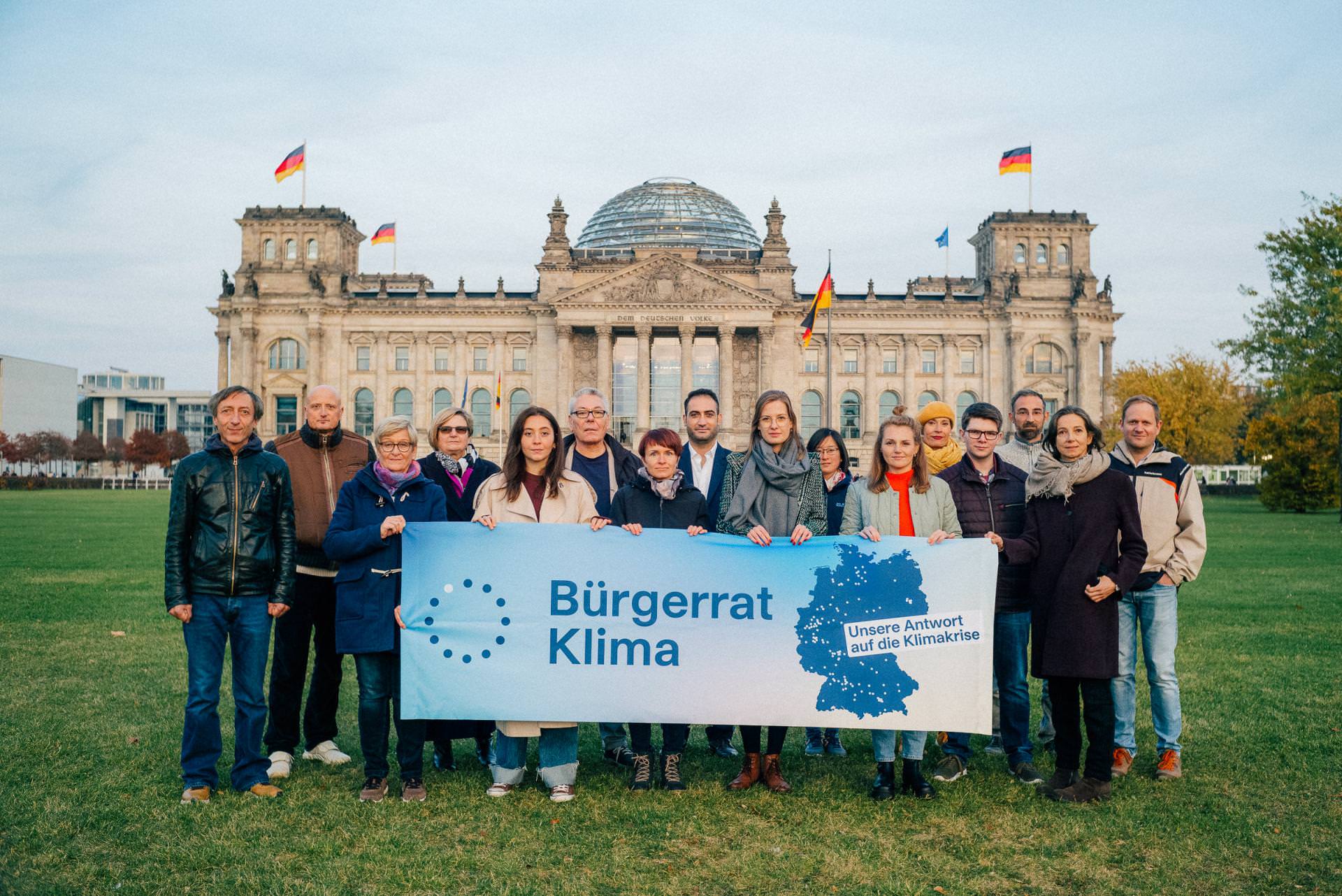 Members of Bürgerrat Klima holding a banner in front of the Reichstagsgebäude