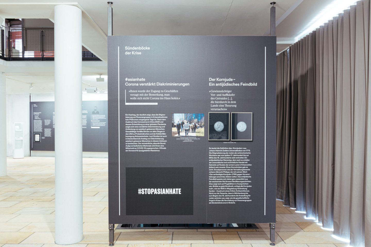 Entrance signage for the exhibition with directional graphic and torn-paper title design.