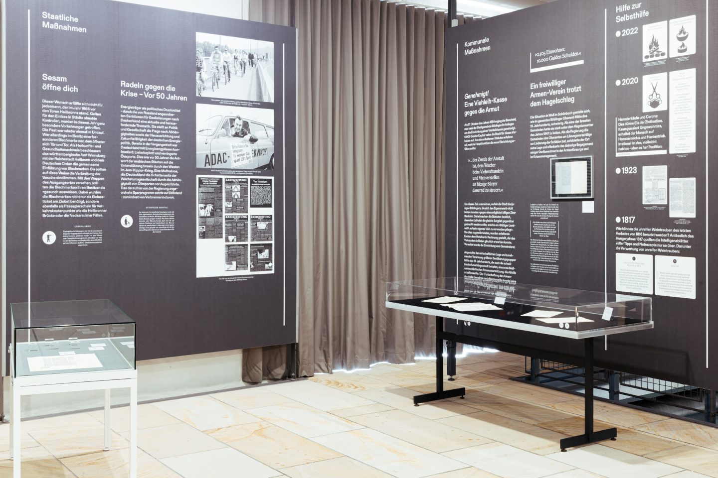 Overview of exhibition architecture with display cases, text panels and historical material.