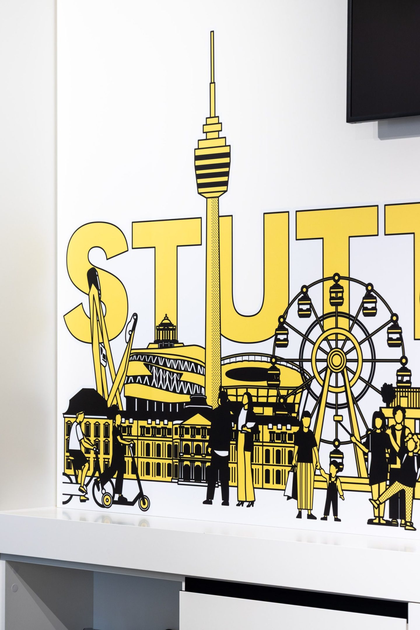 Interior wall graphic for Haus des Tourismus Stuttgart, featuring illustrated city landmarks, local figures and bold Stuttgart lettering as part of the visitor orientation system.