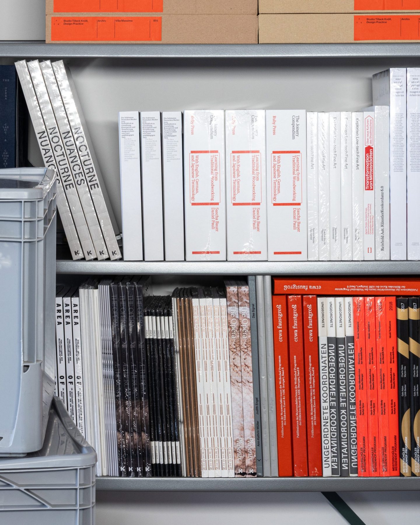 Documentary view of Studio Tillack Knöll’s book archive, featuring editorial design, artist publications and exhibition catalogues on shelving.